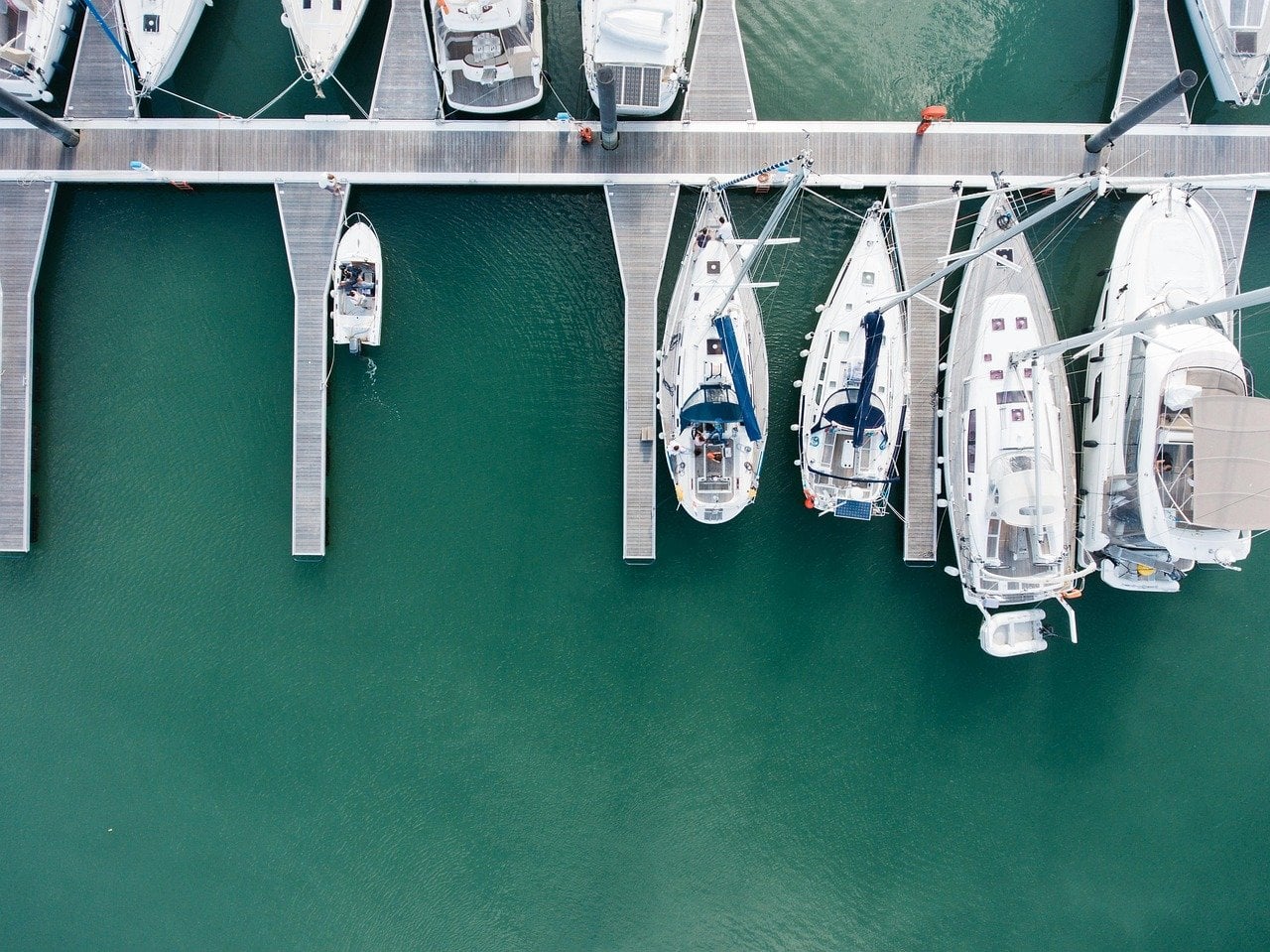 An overhead view of charter yachts berthed in their slips at a Miami marina.
