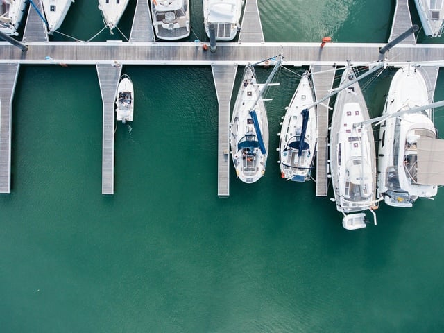 An overhead view of charter yachts berthed in their slips at a Miami marina.